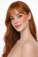 Honor The House Golden Cheek Cream Blush in 04 Solar Bloom on model's cheeks.
