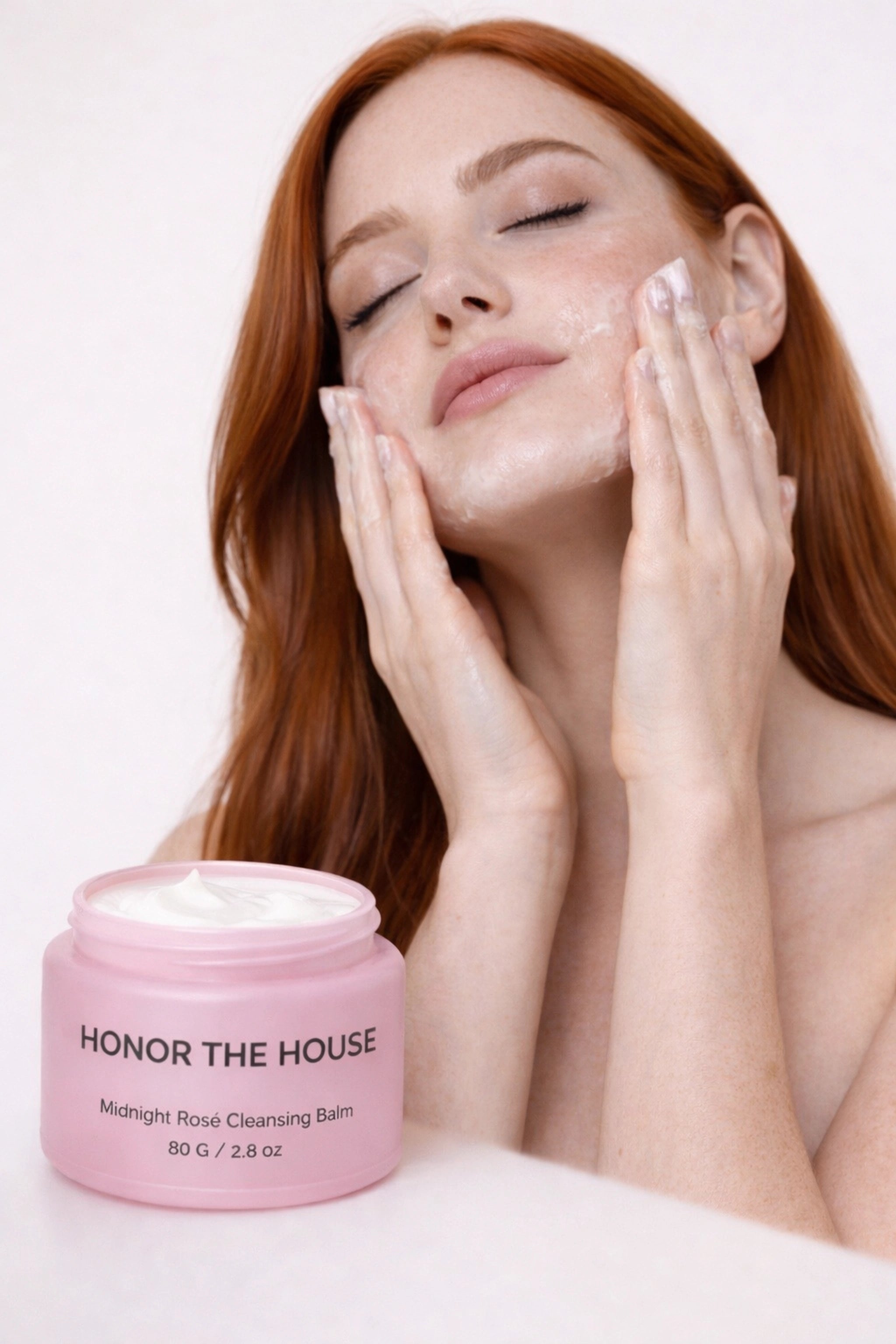Honor The House Cleanse Your Spirit Cleansing Balm in Midnight Rosé shown with a redhead model applying the balm to her face.