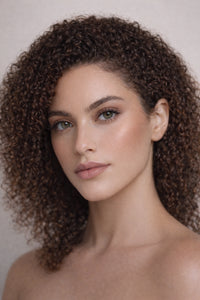 Honor The House Drippin' Gold Liquid Highlighter in Honey Soft Glow on display on a model's cheek.