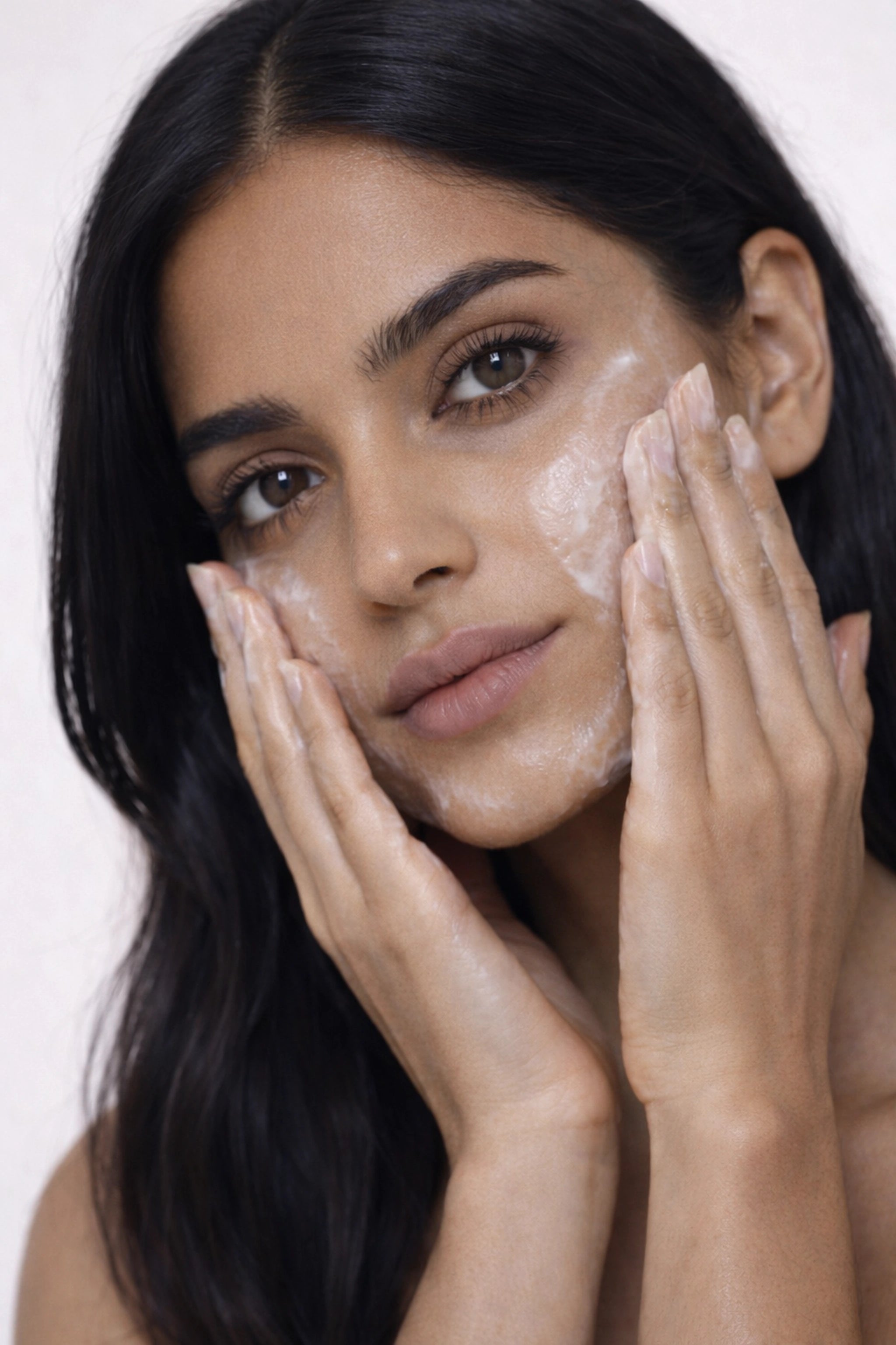 Honor The House Cleanse Your Spirit Cleansing Balm in Midnight Rosé shown with an Indian model applying the balm to her face.