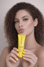 Honor The House Caribbean Sun SPF 30 Tropical Citrus being showcased by model with curly hair.