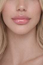 Blonde model showcasing Honor The House Caribbean Sun SPF 30 Lip Balm in Rum Raspberry flavor.