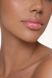 Olive skin model showcasing Honor The House Caribbean Sun SPF 30 Lip Balm in Rum Raspberry flavor.