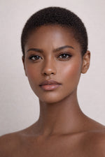 Honor The House Drippin Gold Body Glow in Sun Heat on a short-haired dark skin model.