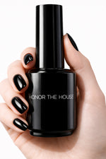 Umbreon Black vegan nail polish on white model hands holding product bottle by Honor The House