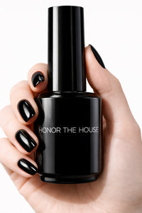 Umbreon Black vegan nail polish on white model hands holding product bottle by Honor The House