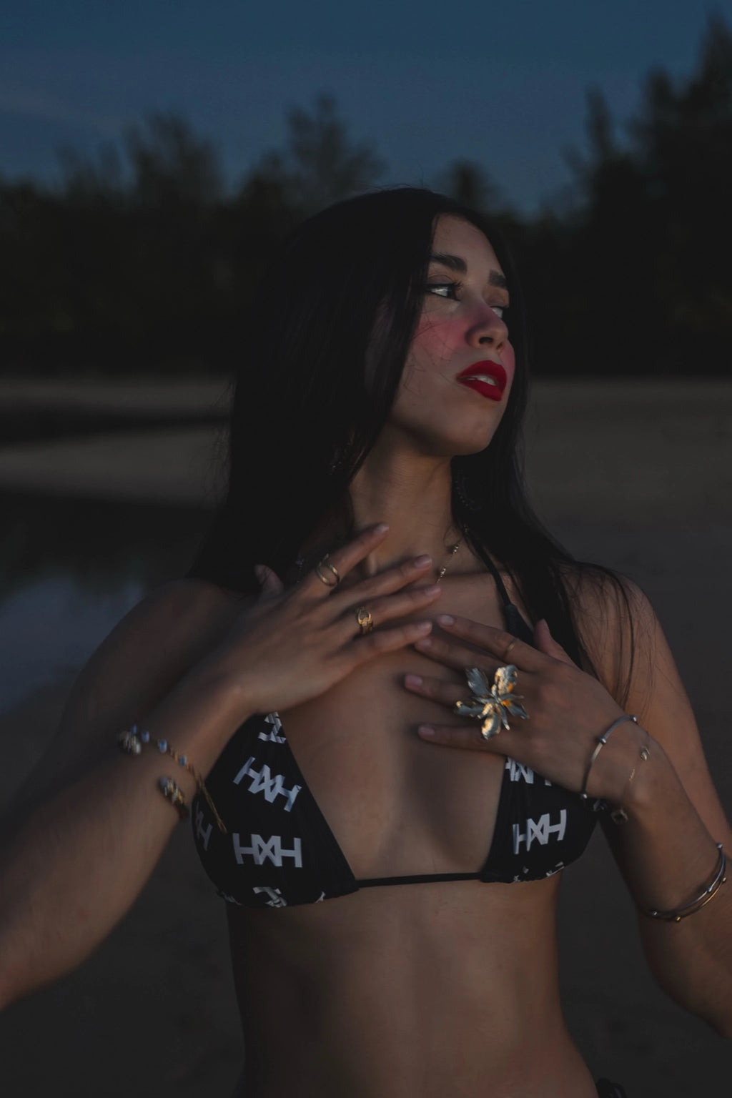 Model wearing Honor The House Breeze Off The Ocean Bikini in Umbreon Black Color at shore during the night in a Goddess pose.