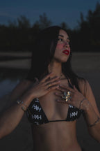 Model wearing Honor The House Breeze Off The Ocean Bikini in Umbreon Black Color at shore during the night in a Goddess pose.